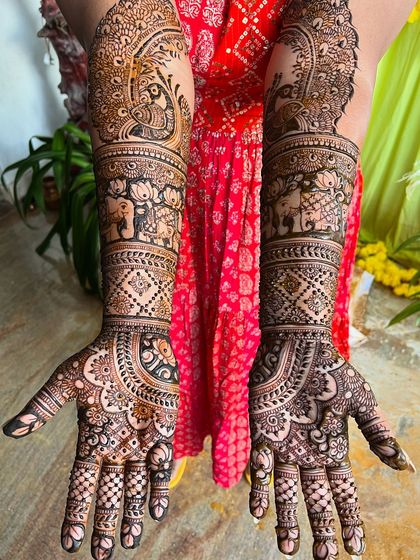 A beautiful example of full-arm bridal mehendi. This design features majestic peacocks and elephants, symbols of grace and strength.