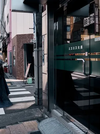 A candid moment on a Tokyo crosswalk. The model is walking away, but the reflection in the glass door adds another dimension. I look for these details, the strange shadows and reflections that make a simple shot more complex.