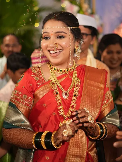 A classic Maharashtrian bridal look with a red saree and traditional jewelry. The makeup is designed to be both beautiful and long-lasting.
