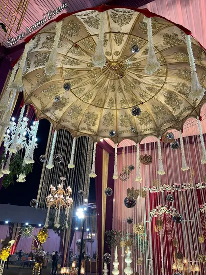 An ornate, oversized umbrella with intricate gold embroidery hangs majestically from the ceiling, adding a layer of traditional grandeur.