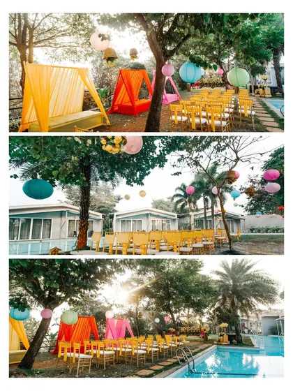 A wide shot of the colorful and festive poolside Haldi decor, with tents and lanterns.