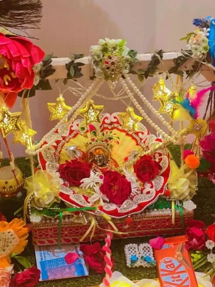 For Janmashtami, I design special jhulas (swings) for Laddu Gopal. This setup includes a decorated swing, star-shaped fairy lights, artificial flowers, and peacock feather details for a festive look.
