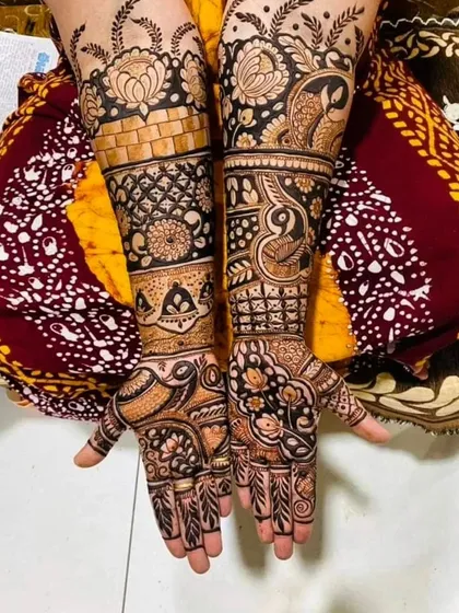 An intricate design that combines floral blocks, brick-like patterns, and delicate vines. The mix of different textures and motifs makes this full-arm mehendi visually captivating.