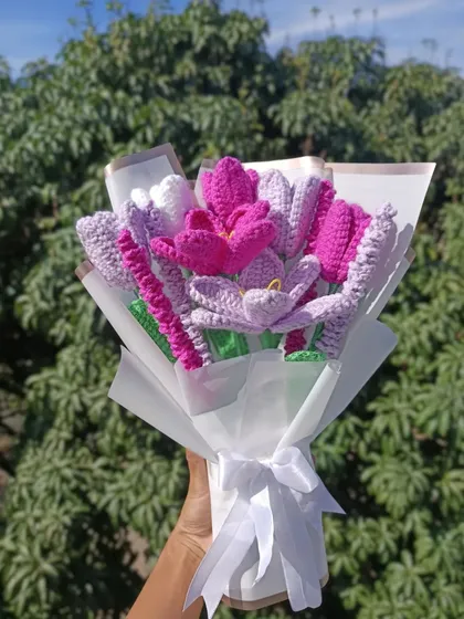 The custom purple and pink bouquet, held up to show the beautiful wrapping.