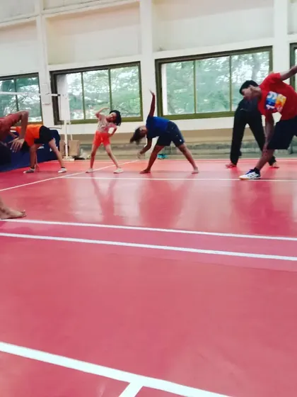 A group of our youth players performing cool-down stretches. This part of the training helps with muscle recovery and flexibility.