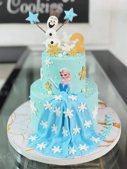 A magical two-tiered cake inspired by Disney's Frozen. This design features Queen Elsa, a flowing fondant dress, and delicate snowflake details, making it a dream come true for any young fan.