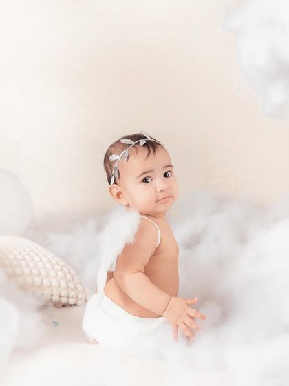 Somewhere in the clouds, a little fairy. This minimalist angel-wing portrait is simple, elegant, and timeless, focusing on the baby's sweet and innocent expression.