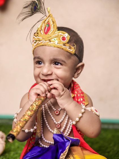 This is a duplicate of image 9. The pure joy of a child's smile is priceless. This little Krishna is captured in a moment of happiness, holding his flute.