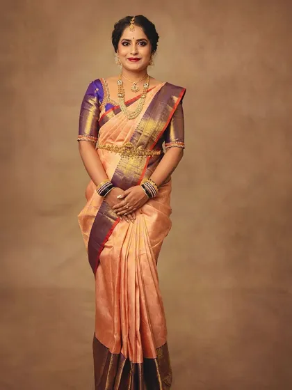 A full-length portrait is essential to showcase the complete silhouette of a garment. This shot displays the beautiful fall of the Kanchipuram silk saree, giving a complete view of its elegance.