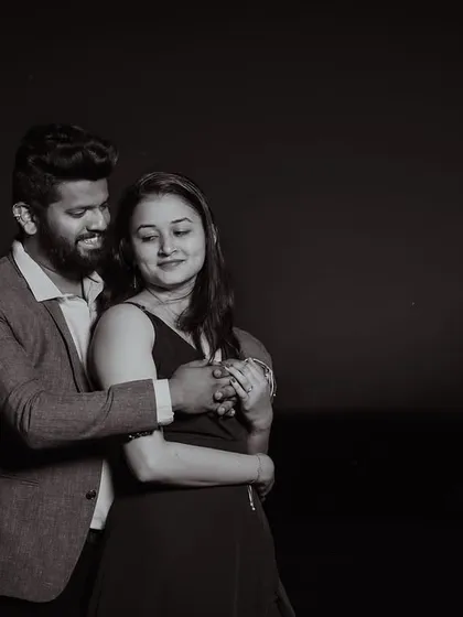 A soft, intimate moment captured in black and white. Even in the dark, the focus is on the couple's gentle interaction and the emotion they share.