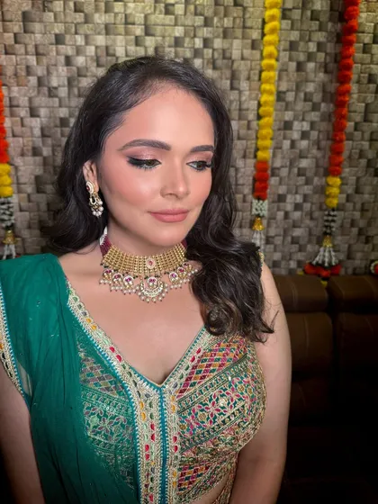 A close-up of a bride during her makeup session for a pre-wedding event. The simple gold-tone choker she chose is perfect for her colorful and festive outfit.