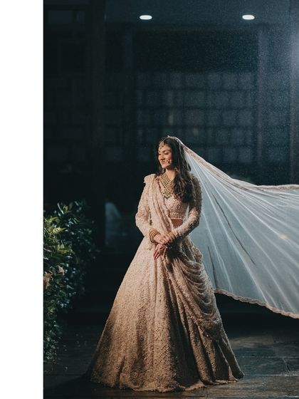 A dramatic shot of Raashi with her veil flowing in the wind. This captures a sense of movement and freedom, creating a powerful and cinematic bridal portrait.