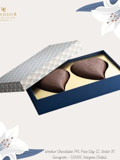 A simple and elegant gift box containing two large, heart-shaped chocolates. This is a perfect small gift for Valentine's Day, an anniversary, or just to say you care.