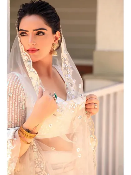 A profile shot capturing a thoughtful moment. This angle highlights the intricate hairstyle with gajra and the delicate embroidery on the dupatta.