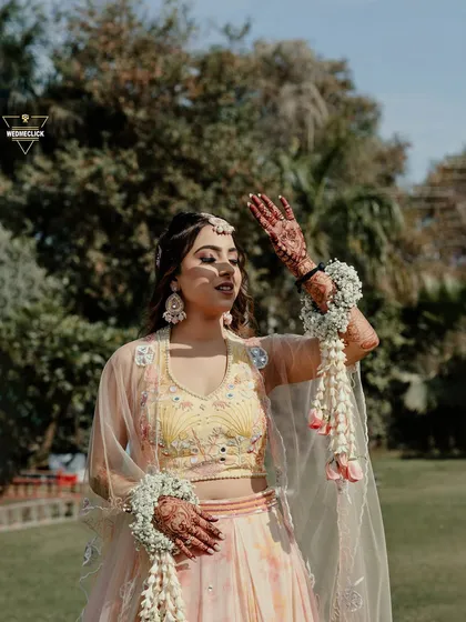 A stunning portrait of the bride, her hands adorned with floral jewelry, basking in the sunshine.