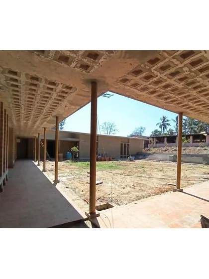The central courtyard during construction, the heart of the 'pranganam' concept. This open space is designed to bring in daylight, promote air circulation, and serve as a gathering point for the community.