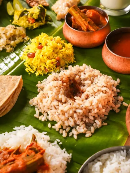 A detailed close-up of different types of rice served during an Onam Sadhya, including matta rice and lemon rice. This shot focuses on the textures and colors of the core elements of the meal.