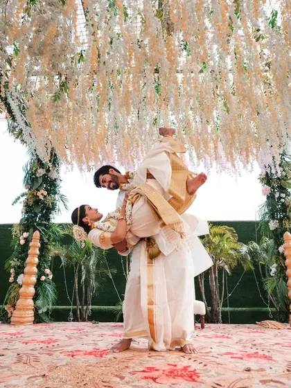 A dramatic lift on the mandap. This shot is full of joy and celebration, perfectly framed by the floral decorations.