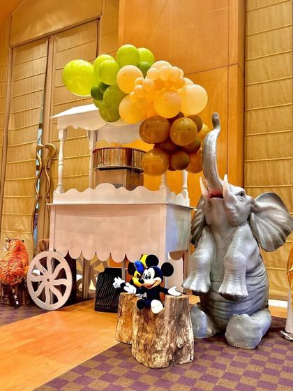 Another view of the playful elephant and Mickey Mouse setup. The unique color combination of the balloon garland adds a modern twist to the classic jungle theme.