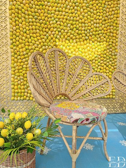 The Haldi seating area, with a cane peacock chair set against a wall of lemons. This setup is both rustic and chic, blending natural textures with a bold pop of color.