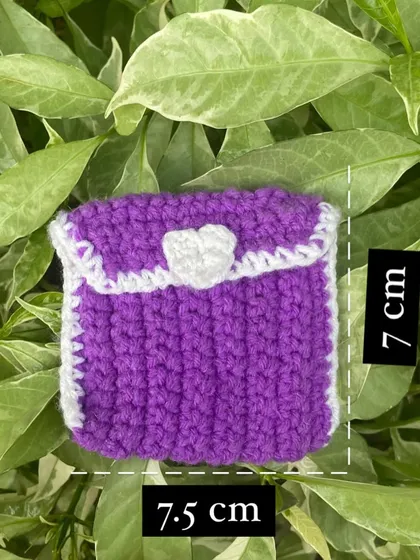 This is my little crochet pouch, perfect for AirPods or coins. It's 7.5 cm by 7 cm, with a cute heart on the flap. This one is purple and white, a classic combo.