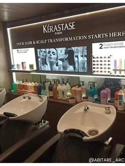 The professional hair wash and treatment area, featuring ergonomic basins and a fully stocked Kérastase product display. The design focuses on functionality and brand integration, ensuring a premium experience for both stylists and clients.