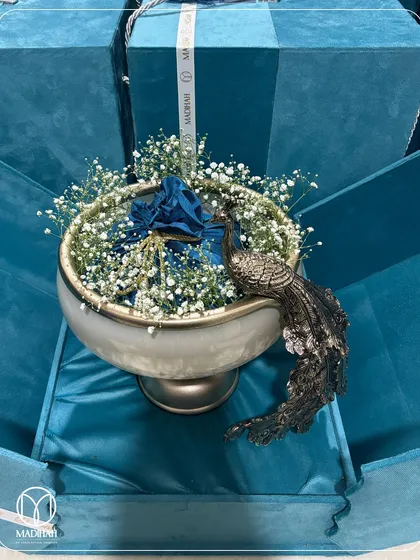 Our Peacock Bowl hamper in a striking blue velvet box. The contrast between the cool blue and the warm metallic finish of the bowl makes for a truly memorable and elegant gift.