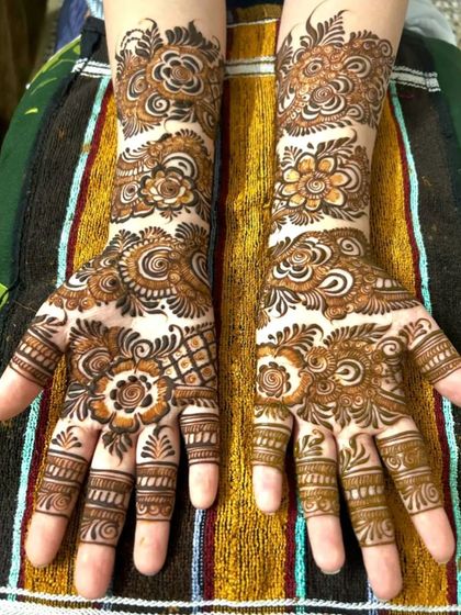 A beautiful floral Indo-Arabic design that covers the hands from the wrist down. The pattern is a lovely mix of flowers, leaves, and swirls, perfect for any festive occasion.
