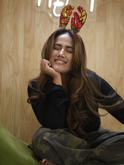 A playful moment captured after her hair makeover. The festive headband adds a fun touch to her gorgeous new hairstyle.