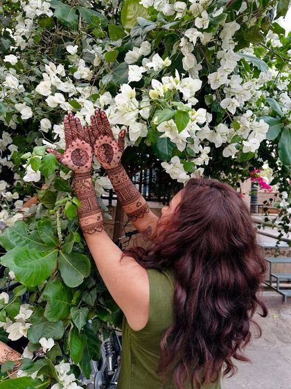 Capturing a moment of joy as a client shows off her palm designs, with detailed mandalas and finger patterns.