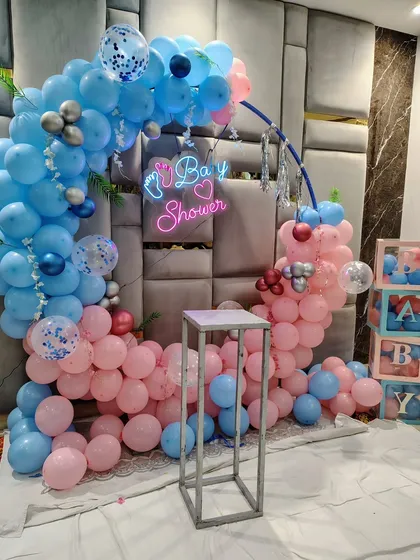 The baby shower balloon ring decorated with green leaves for a touch of nature.
