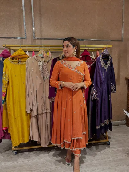 The angrakha style is incredibly flattering as it cinches the waist. This orange suit is a great example of how traditional silhouettes can feel fresh and modern with the right color and fabric.
