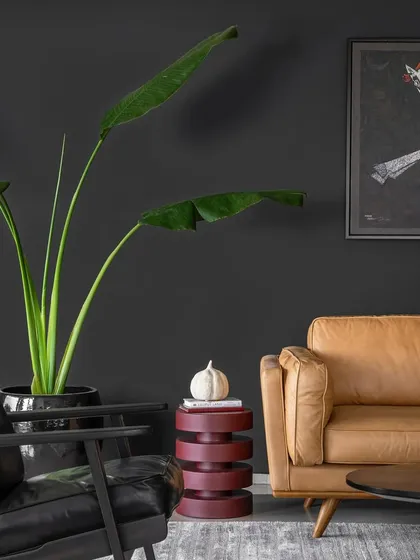 In this corner of Apartment 1600, we paired a classic black leather armchair with a bold, stacked side table against a dark wall. The composition highlights our ability to mix mid-century modern elements with contemporary art for a layered, masculine aesthetic.