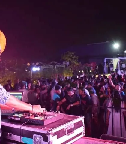 A shot of me at my console, facing a sea of happy faces at a private party. My goal is simple: keep the dance floor packed and the smiles wide. This is what I live for.
