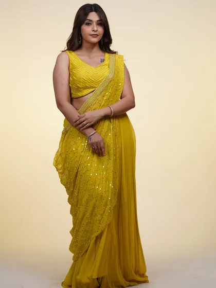 A full-length view of the yellow pre-draped saree. The bright color and easy-to-wear style make it perfect for a haldi ceremony or daytime event.