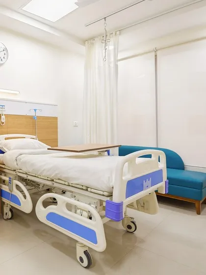 This patient room at Sarvodaya Hospital includes a comfortable sofa for family members and large windows to maximize natural light. The thoughtful layout ensures the space is functional for care and comfortable for recovery.