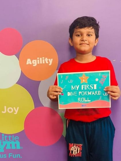 Look at that proud smile. This grade schooler has successfully performed his first dive forward roll. Acknowledging these moments helps build a child's confidence and motivation.