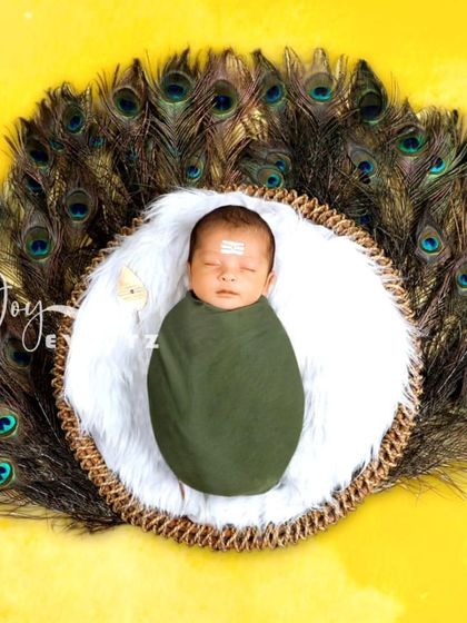 Celebrate your faith and heritage with a divine Lord Murugan themed newborn shoot. We use a fan of peacock feathers and a traditional 'tripundra' on the baby's forehead to create a respectful and beautiful image.