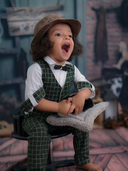 A moment of pure, uninhibited joy. This little boy's big laugh is the highlight of this fun, rustic-themed photoshoot.