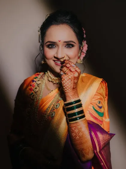 A playful and charming portrait of the bride, her hand gently touching her face, highlighted by a beautiful ray of light.