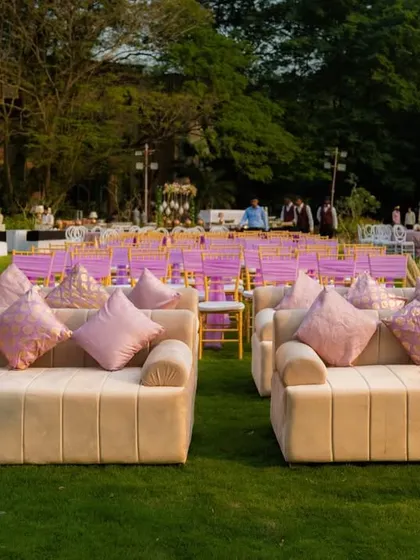 Comfortable and stylish lounge seating was provided for guests to relax and socialize. These plush sofas with pink cushions offered a comfortable alternative to the main seating area, adding a touch of informal elegance to the outdoor gala.