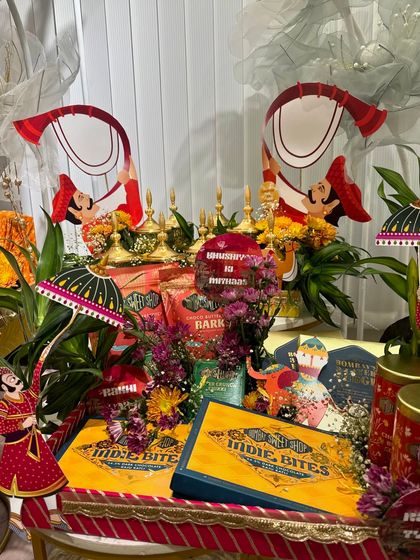 A vibrant and colorful Rakhi trousseau platter. This is perfect for a bride-to-be, featuring a mix of traditional Rajasthani decor and modern snacks.