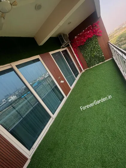 I can turn any urban balcony into a green oasis. This high-angle shot shows a complete transformation with wall-to-wall artificial turf, providing a maintenance-free lawn with a stunning city view.