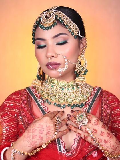 This stunning look with green eyeshadow and a bold lip was created in our bridal makeup class. We teach students how to play with color to complement bridal outfits.