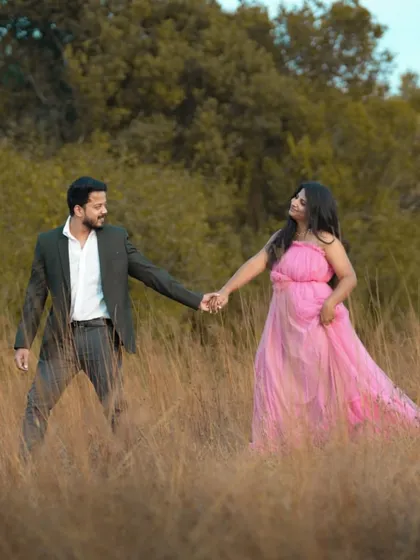 A romantic maternity shoot in a field of tall grass. The pink tulle gown adds a soft, dreamy quality to this beautiful couple's portrait.