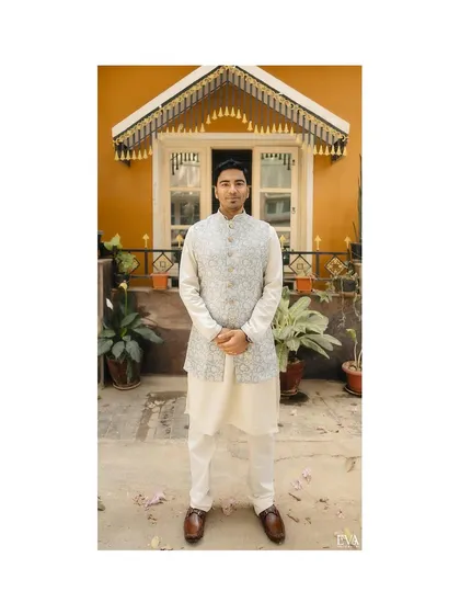 The groom, Bhuvan, stands ready for the ceremony, captured in a full-length portrait against a charming backdrop.