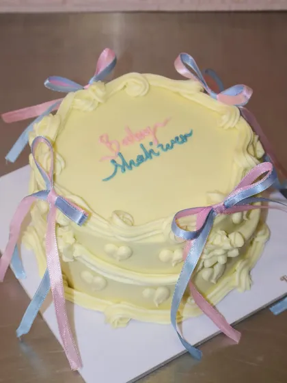 This vintage-style baby shower cake is all about the details, from the heart-shaped impressions on the side to the perfectly tied pastel ribbons.