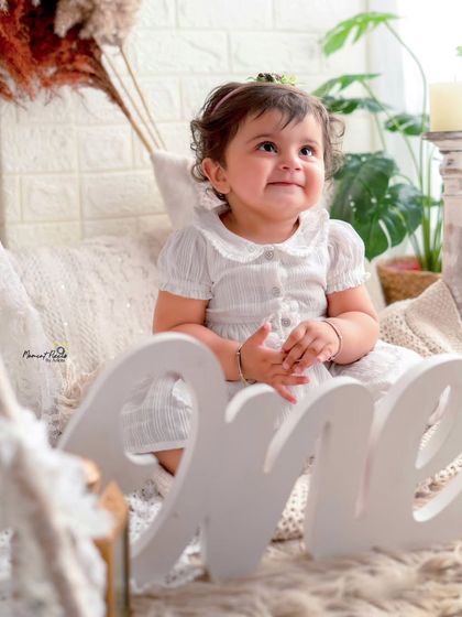 A smile that lights up the whole room. This little girl is the picture of happiness as she celebrates her first birthday in a bright, bohemian-style setting.