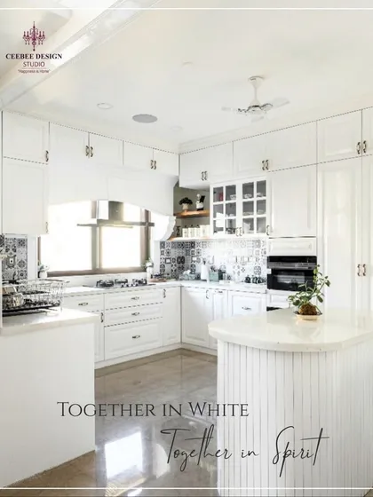 An all-white kitchen with shaker-style cabinets and patterned tile accents, creating a bright and timeless look.