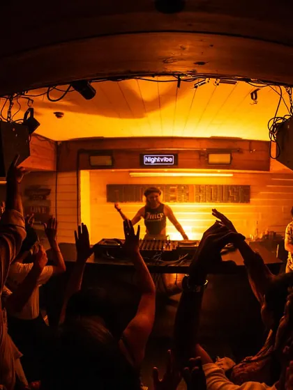 A wide shot from the back of the venue, showing the crowd with their hands up as I command the stage.